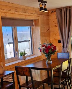 uma mesa de jantar com um vaso de flores em Cozies Cabin em Billy