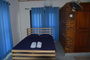 a bedroom with a blue bed with two white towels on it at Mereiyans Village Villa in Ampara