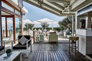 - une terrasse avec un bouquet de chaises et de tables dans l'établissement Rouge Hotel International, à Milano Marittima