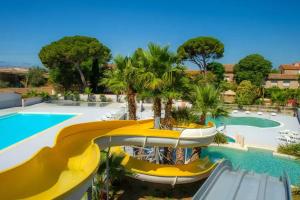 a resort with a slide and a swimming pool at Mobil Home climatisé 3 chambres - Parc des 7 fonts in Agde