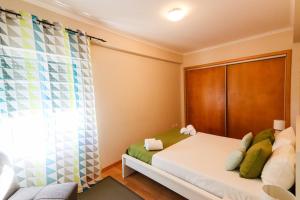 niewielka sypialnia z łóżkiem i zasłoną w obiekcie WelcomeBuddy - Beatrice Downtown City Flat w mieście Ponta Delgada