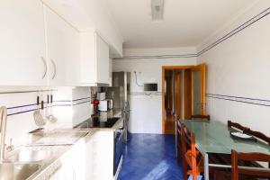 cocina con armarios blancos y suelo de baldosa azul en WelcomeBuddy - Beatrice Downtown City Flat en Ponta Delgada