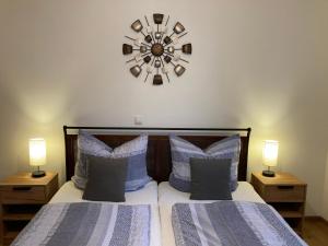 a bedroom with two beds and a clock on the wall at Ferienwohnung Am Hochkelberg in Bereborn