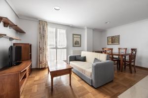 a living room with a couch and a table at Apartamentos El Cid in Burgos