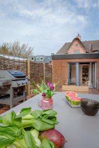 een tafel met groenten en fruit op een patio bij Haus Grüne Düne in Wenningstedt