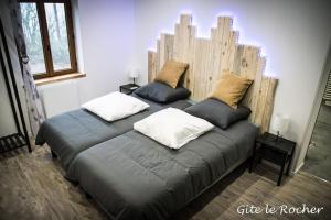 uma cama com dois travesseiros em um quarto em Gîte Le Rocher em Chouvigny
