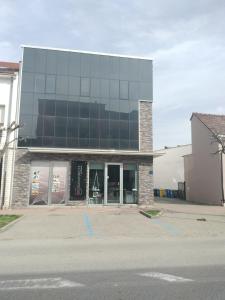 a building with a parking lot in front of it at Apartman DJ in Đakovo