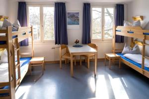 a room with bunk beds and a table and chairs at Jugendherberge Lübeck Vor dem Burgtor in Lübeck +19 photos