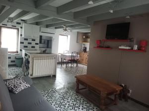 ein Wohnzimmer mit einem Sofa, einem TV und einem Tisch in der Unterkunft karine in Boucau