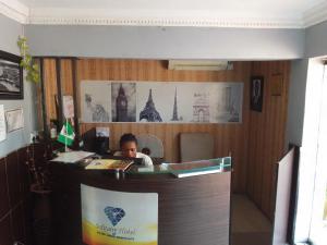 een man aan een bureau in een kantoor bij Hotel bougainvillea Victoria island in Lagos