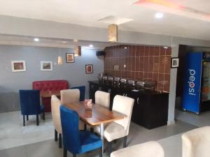 een eetkamer met een houten tafel en blauwe stoelen bij Hotel bougainvillea Victoria island in Lagos