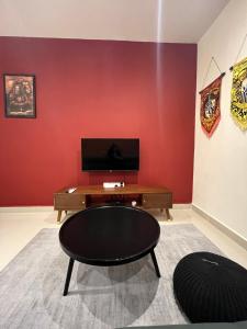 a room with a red wall with a table and a chair at THE SHORE KOTA KINABALU 5Pax Family Room in Kota Kinabalu