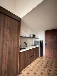 a kitchen with a sink and a wooden door at VILLA DEL ROSARIO in Tena