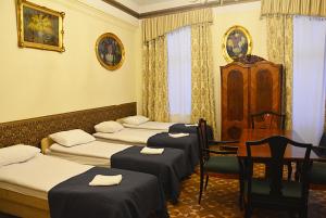 a room with four beds and a table and chairs at Florian 5 Apartment in Krakow
