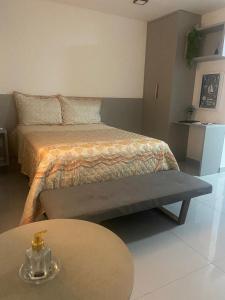 a bedroom with a bed and a table and a table at One way in João Pessoa