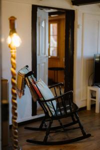 un fauteuil à bascule dans un salon à côté d'une lampe dans l'établissement Bijou Beatus - Lakeview Sunset Retreat, à Merligen