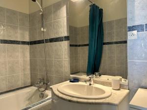 uma casa de banho com um lavatório, uma banheira e um chuveiro em 544 - Appartement T3 avec magnifique vue mer em Erquy