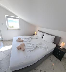 un letto bianco con due asciugamani sopra di Apartment 1 D&D, Baška a Baška