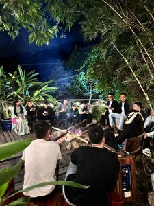 um grupo de pessoas sentadas à volta de uma fogueira em Homestay ECO MAY5 TRAVEL em Ha Long