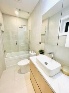 a white bathroom with a sink and a toilet at Modern Apartment Close To The Beach with Parking in Toronto