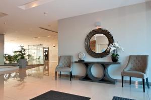 a lobby with two chairs and a mirror on a wall at The Grand Apartments in Gold Coast