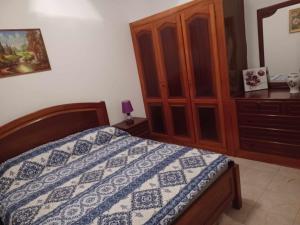 a bedroom with a bed and a wooden cabinet at Repousando in Mão para Trás