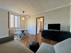 a living room with a couch and a flat screen tv at BIG Historical Colonne in Milan