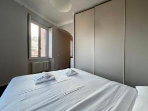 a bedroom with a white bed with two towels on it at BIG Historical Colonne in Milan