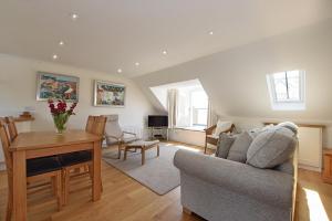 a living room with a couch and a table at Penthouse on the Harbour Pittenweem in Pittenweem