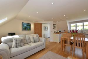 a living room with a couch and a table at Penthouse on the Harbour Pittenweem in Pittenweem