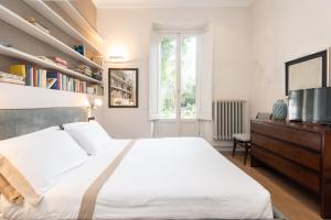 ein Schlafzimmer mit einem großen weißen Bett und einem Fenster in der Unterkunft Raffaello Apartment by Firenze Prestige in Florenz