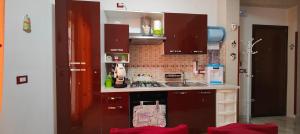 eine kleine Küche mit braunen Schränken und einem Waschbecken in der Unterkunft Casa Zibè in Isola delle Femmine