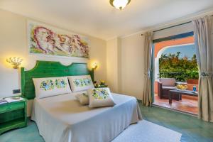 una camera con letto e vista su un patio di Villaggio Cala Ginepro Resort & SPA a Orosei