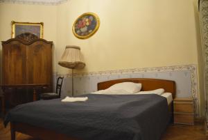 um quarto com uma cama e um relógio na parede em Florian Apartment 8 em Cracóvia