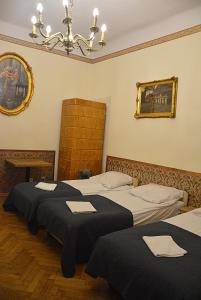two beds in a room with a chandelier at Florian Apartment 8 in Kraków