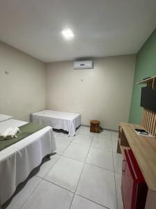 a room with two beds and a room with a mattress at POUSADA AMORIM in Santo Amaro