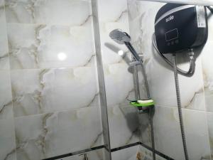 a shower in a bathroom with a blow dryer at Huascarán wasi, cómodo, con wifi y ducha caliente in Huaraz
