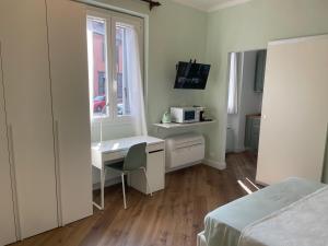 a bedroom with a desk and a bed and a window at Monolocale Salvia Self check in in Pavia