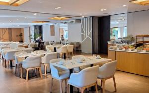 un restaurante con mesas y sillas blancas y una barra en Rincón del Duende Resort y Spa de Mar en Mar de las Pampas