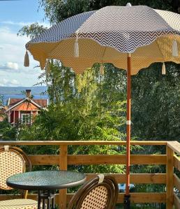 - une table avec un parasol sur la terrasse dans l'établissement Hemma hos Jeanette & Micke på Peresgården, à Vikarbyn