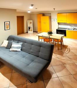 Al Glicine Apartments في لازيسي: غرفة معيشة مع أريكة زرقاء وطاولة