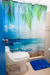 a bathroom with a toilet and a tropical shower curtain at Studio 4 Casiguaya with Garden access in Vieques