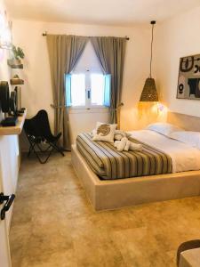 a bedroom with a bed and a desk and a window at Le Lanterne Resort in Pantelleria