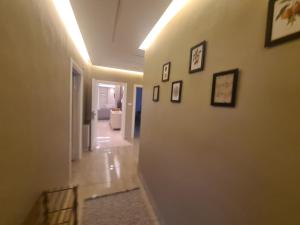 un pasillo con una pared blanca con cuadros. en Amman's most prestigious, en Amán