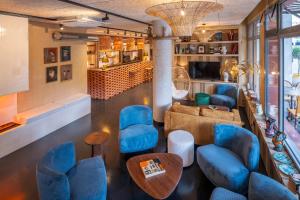 une chambre avec des chaises et des tables bleues dans l'établissement Kopster Hotel Paris Porte de Versailles, à Paris