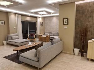 Amman's most prestigious في عمّان: غرفة معيشة مع كنب وطاولة في غرفة