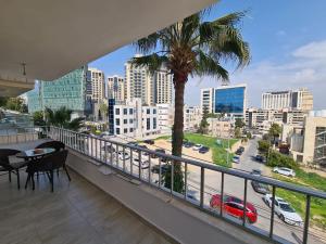 a balcony with a palm tree and a view of a city at Amman's most prestigious in Amman