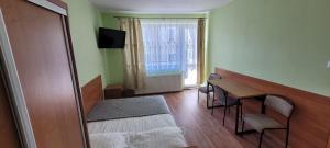 a room with a bed and a table and a window at Kojo 2 in Władysławowo