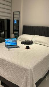 ein Laptop auf einem Bett in der Unterkunft monoambiente completo y central in Santa Cruz de la Sierra