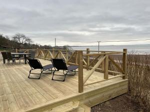 una terraza de madera con 2 sillas y una mesa. en Flemma Gård The lake view with sauna en Vreta Kloster